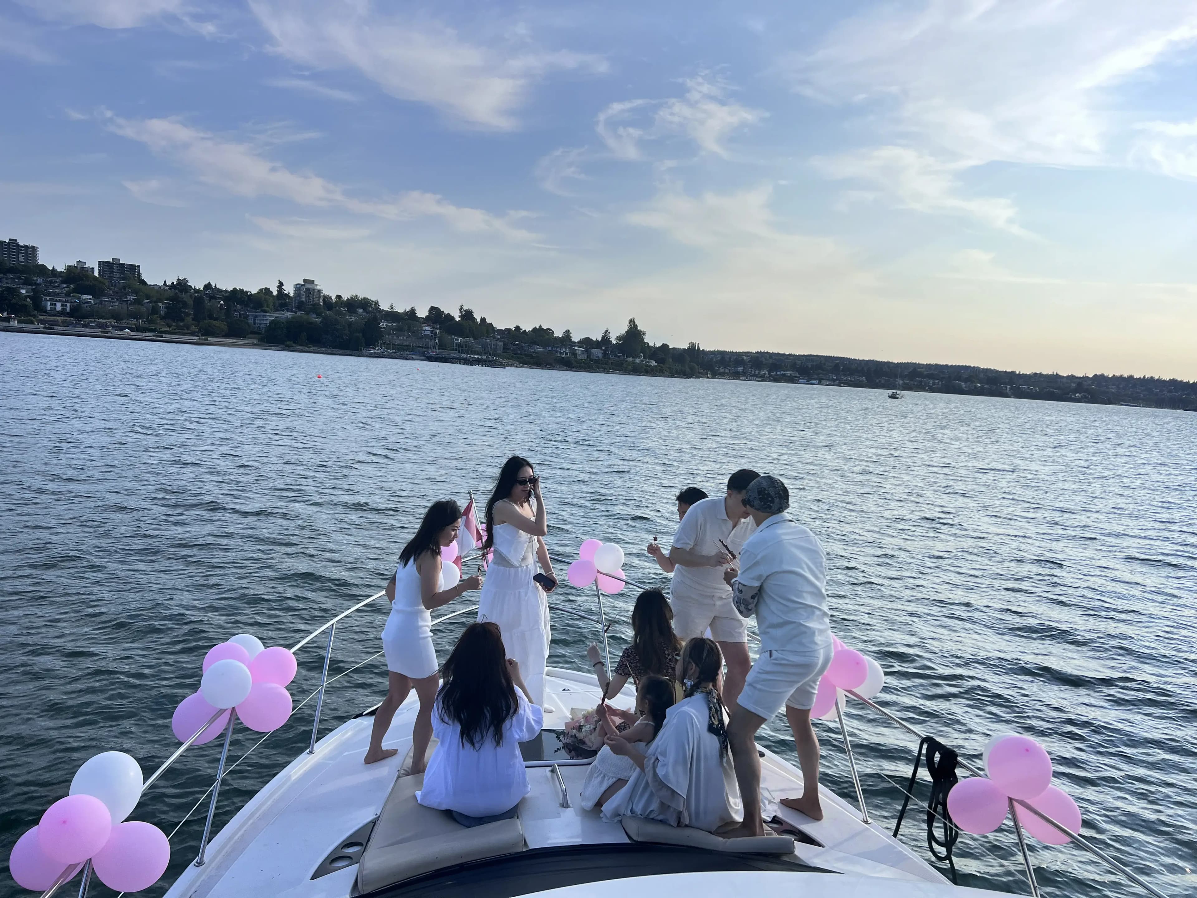 Guests celebrating on the bow of a yacht decorated with pink balloons